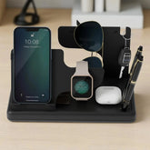 Multi-device charging stand holding phone, watch, sunglasses, keys, and pen on a wooden surface.
